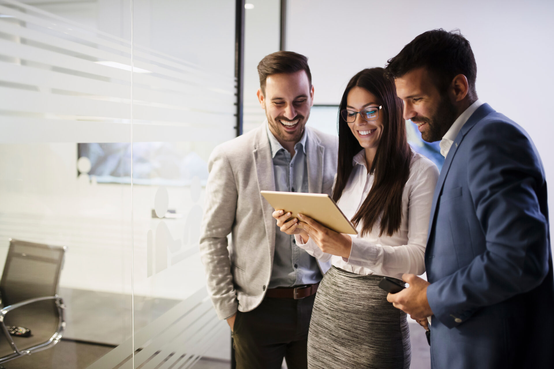 Three people around a tablet discussing about medical coding services